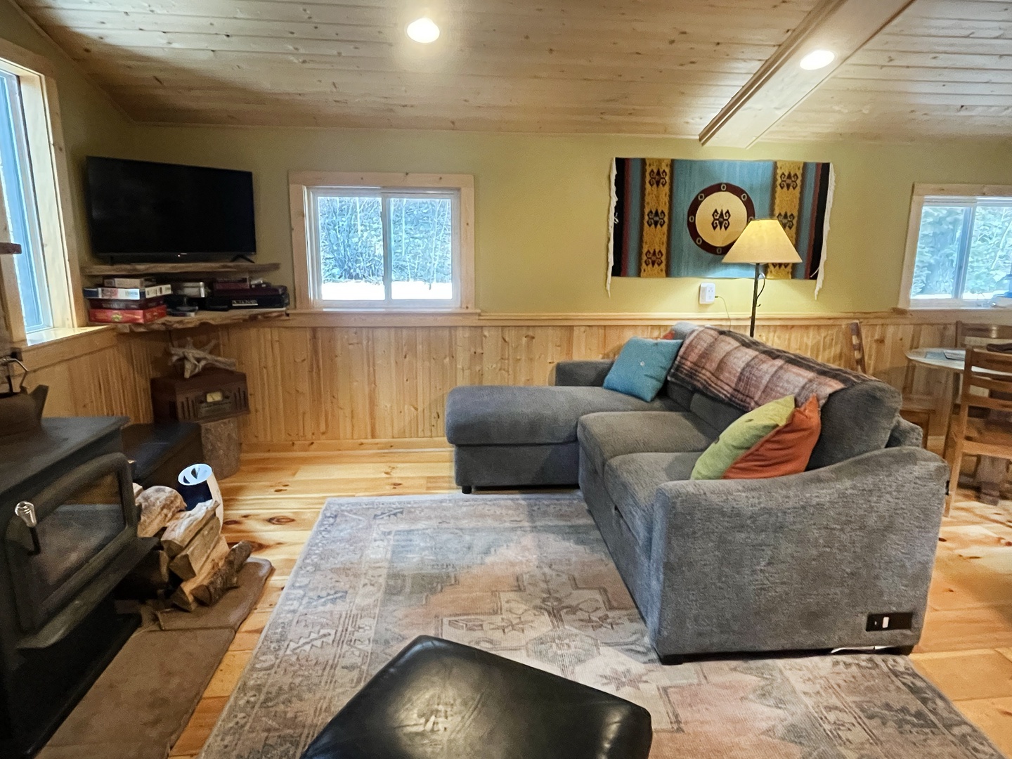 Sink into this cozy sectional sofa surrounded by warm wood and natural light streaming through windows.