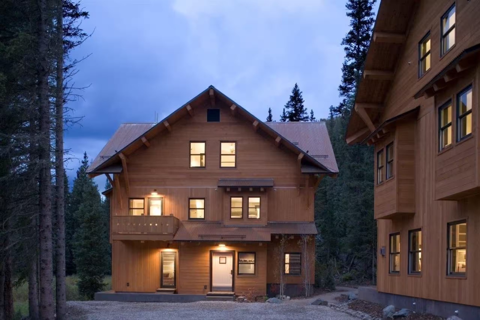Nestled among towering pines, this mountain lodge welcomes you with warm, glowing windows at twilight. The rustic exterior and charming balconies set the stage for your peaceful alpine escape.