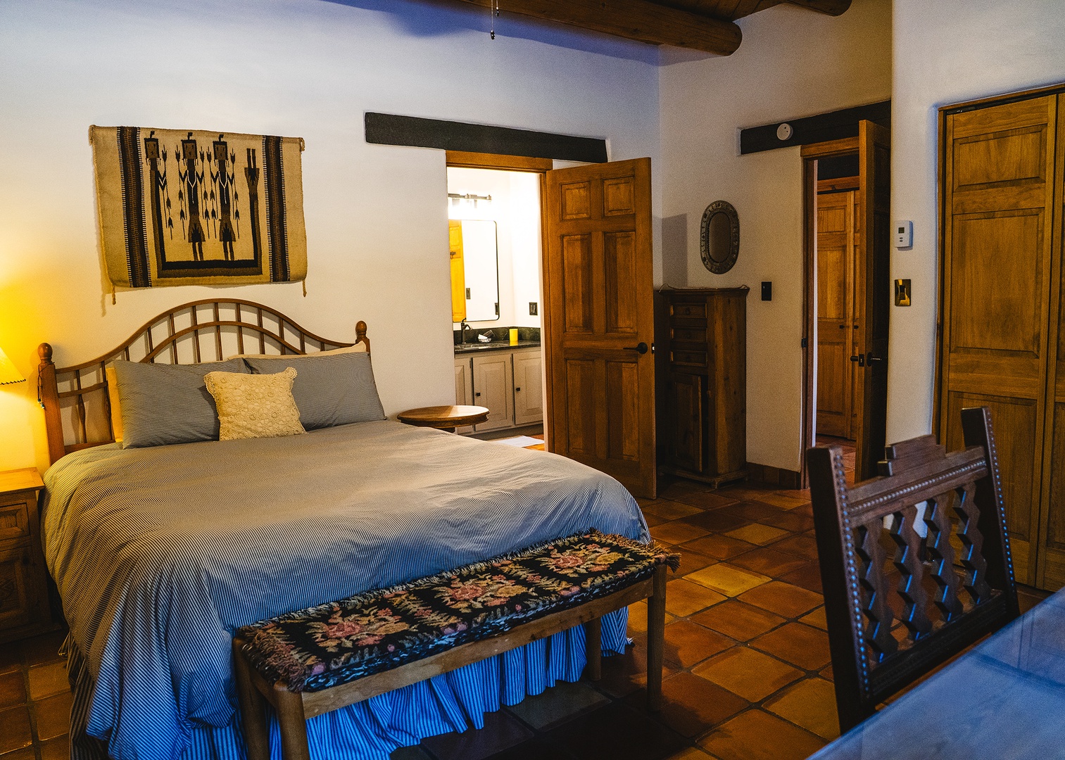 Your adobe-style bedroom blends rustic charm with handcrafted details, featuring exposed beams, Native American textiles, and warm terra cotta tiles.