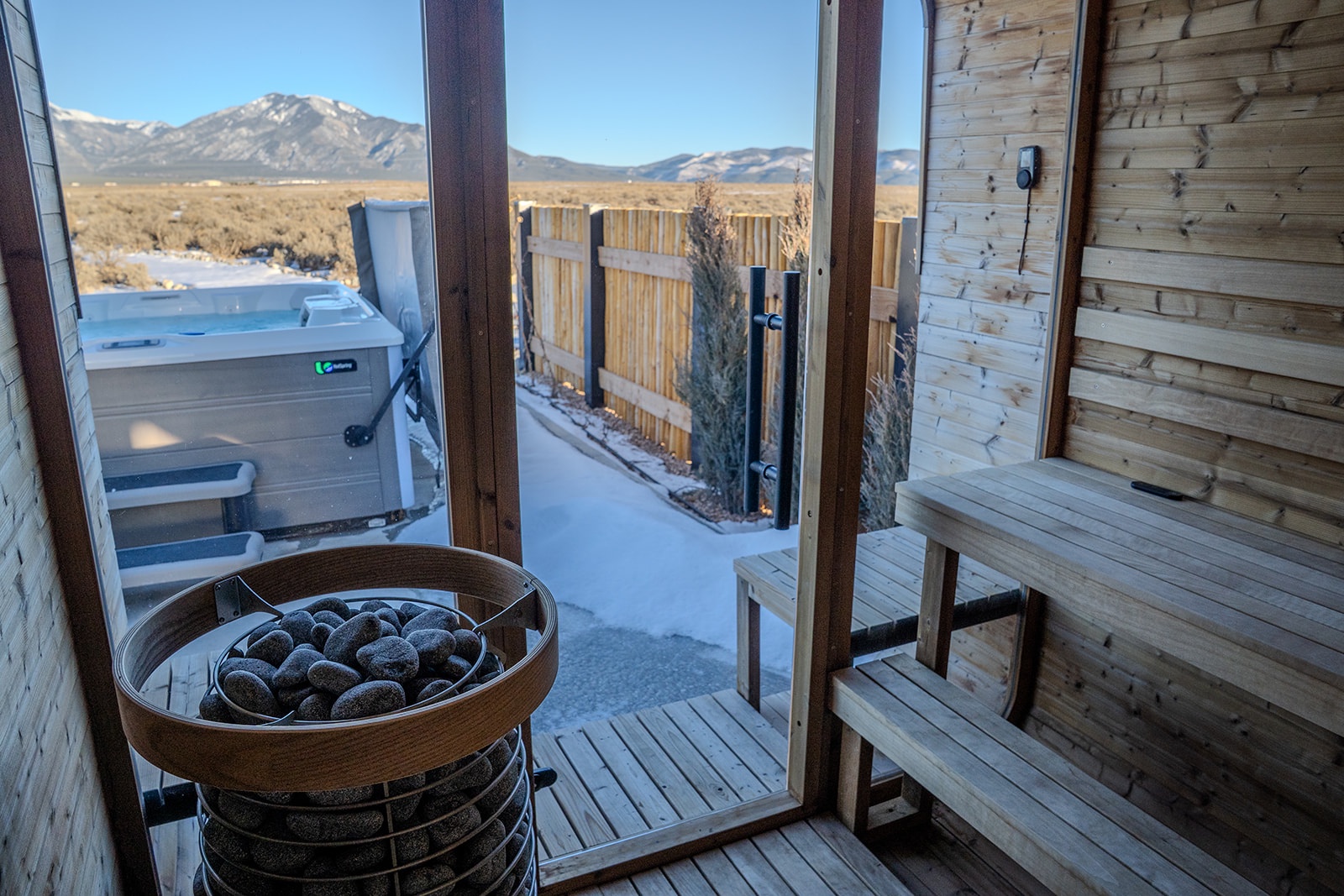 Warm up with stunning mountain views from your private sauna, featuring a traditional heated stone heater and hot tub access.