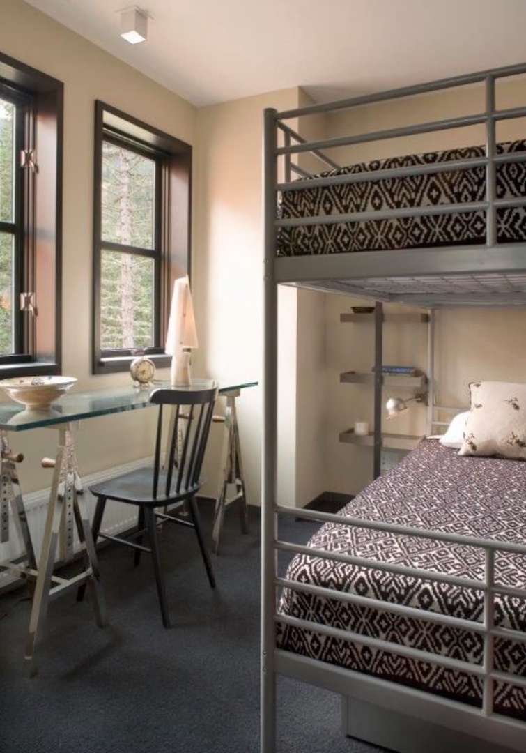 Your cozy bedroom features a stylish bunk bed and a charming workspace by the window, perfect for catching up on reading or planning your next adventure.
