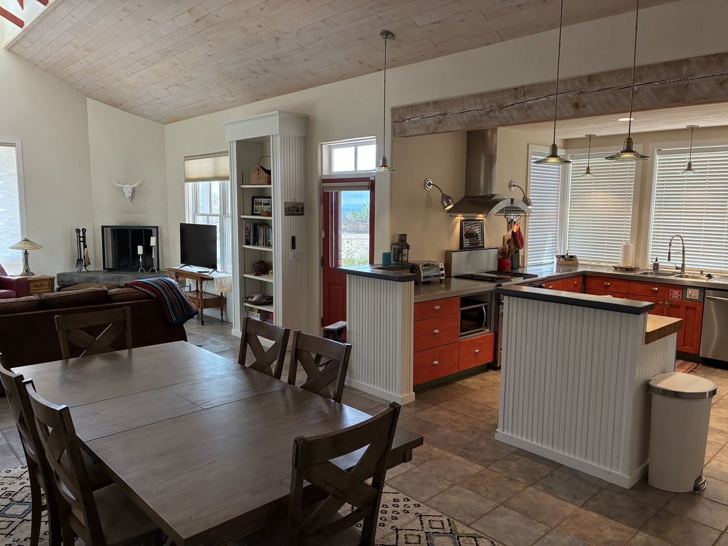 Gather around the spacious dining table and enjoy ocean breezes drifting through your fully equipped kitchen. Natural light pours in through large windows while rustic wood ceilings add warmth to your coastal retreat.
