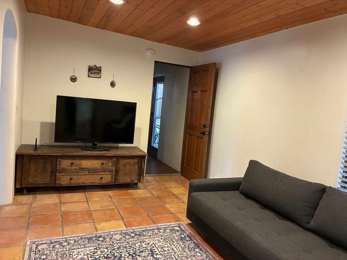 Relax in your cozy living area, where warm wood tones and terracotta floors create a welcoming retreat after exploring the area.