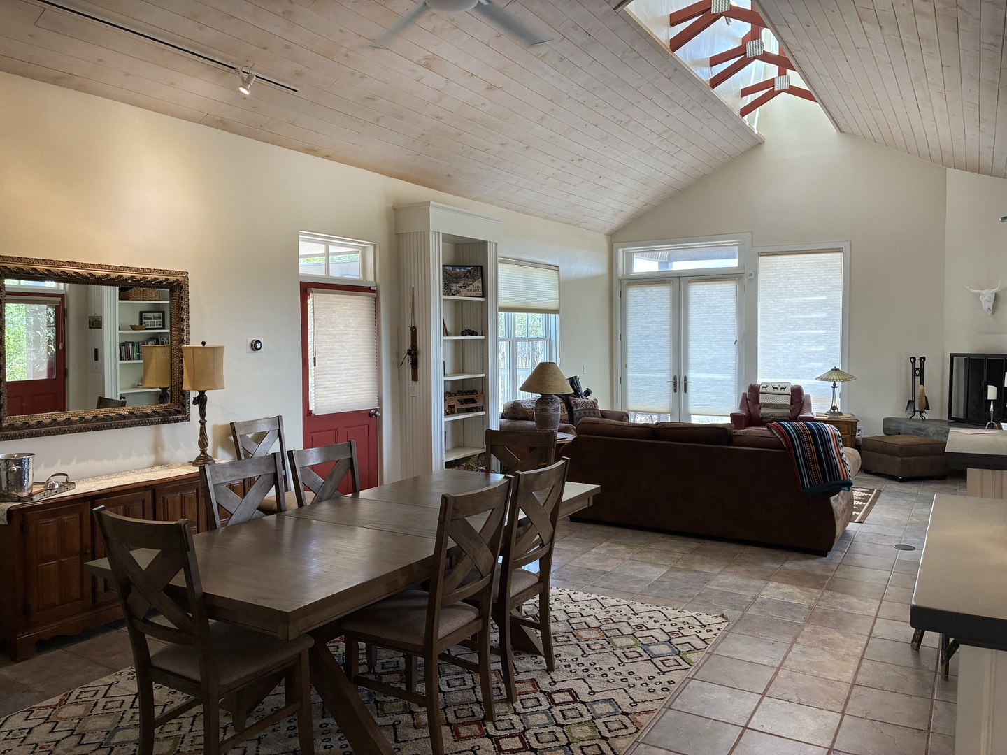 Bright, open-concept living space with soaring cathedral ceilings, rustic wood details, and abundant natural light. Perfect for unwinding after exploring the outdoors.