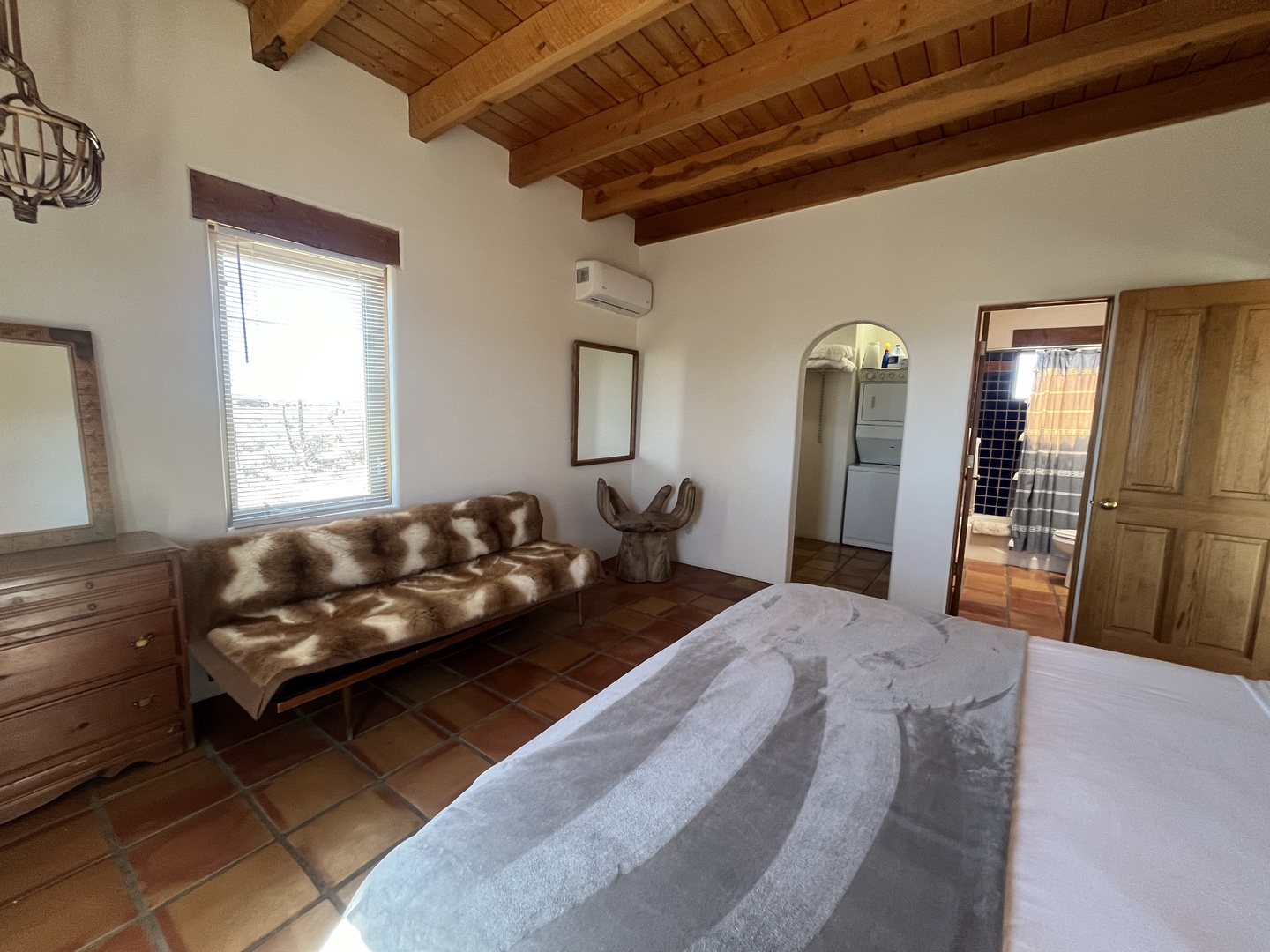 Your rustic bedroom features exposed wooden beams, cozy seating, and authentic tile floors that create a warm, traditional atmosphere for restful nights.