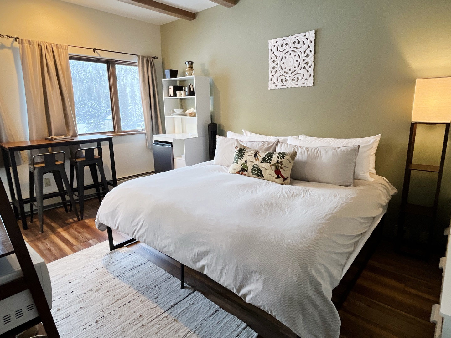 Drift off peacefully in your cozy bedroom, where crisp white linens meet rustic wood beams and soft lighting creates the perfect retreat.