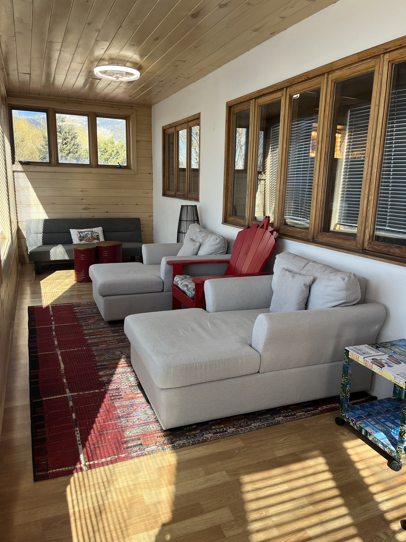 Sink into plush seating while morning light streams through expansive windows, revealing stunning mountain views from your cozy alpine retreat.