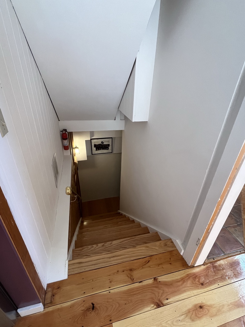 Polished wood stairs guide your way to cozy spaces below, with warm lighting welcoming you at every turn.
