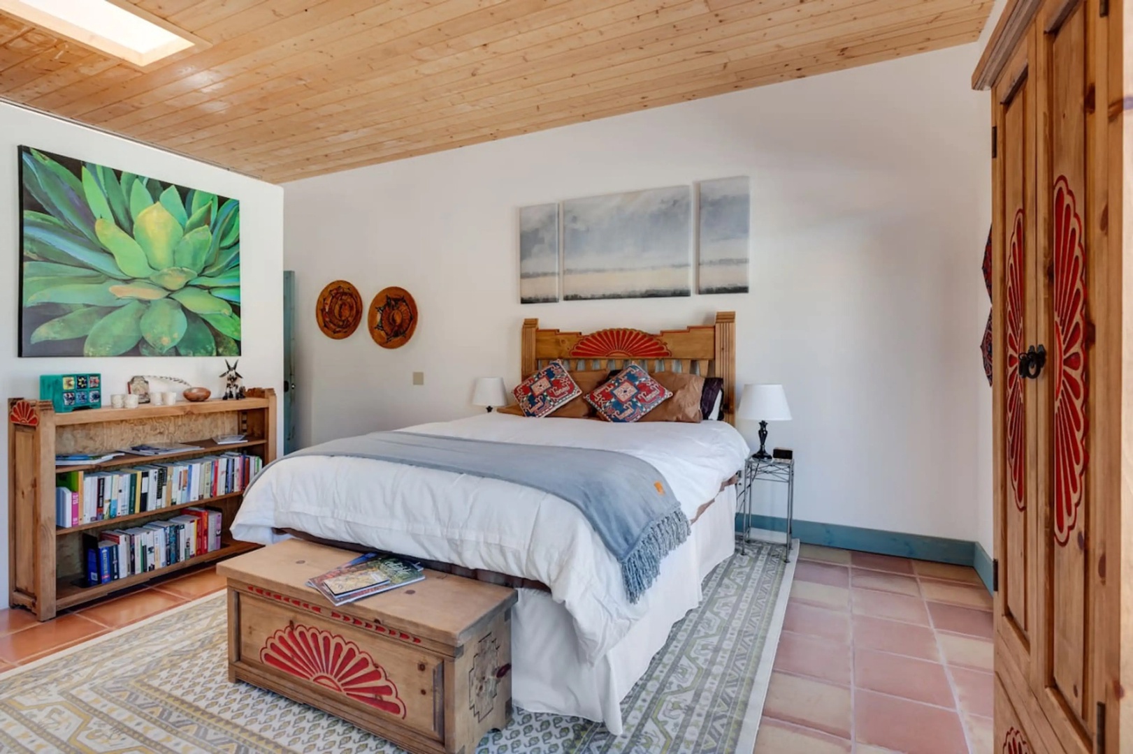 Sink into crisp linens and a plush duvet in your serene bedroom retreat. Warm wood accents, vibrant artwork, and artisan decor create a cozy, inviting ambiance for your stay.