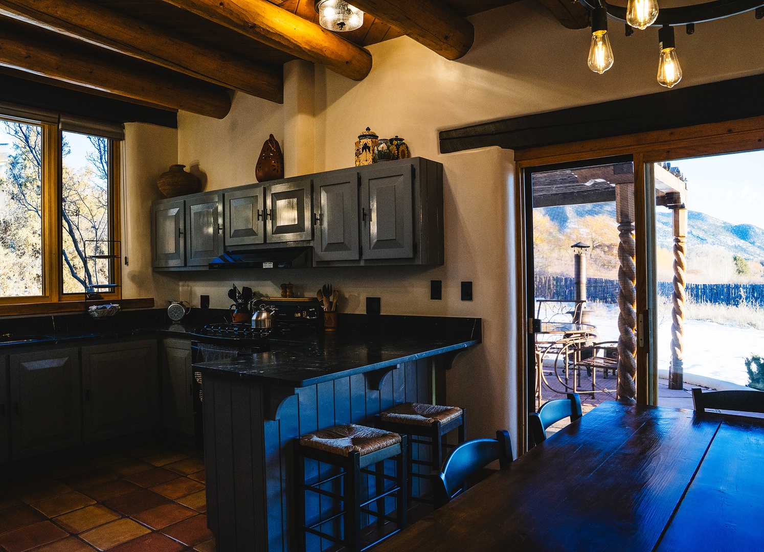 Your rustic kitchen features exposed beams, granite counters, and mountain views through large windows—perfect for cooking with scenic inspiration.