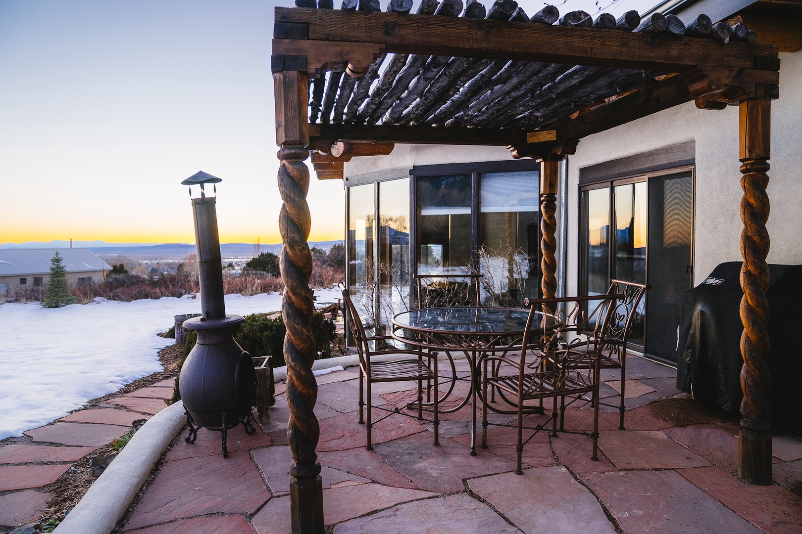 Cozy covered patio with dining table and chairs, perfect for morning coffee or evening meals while enjoying mountain views and crisp winter air.
