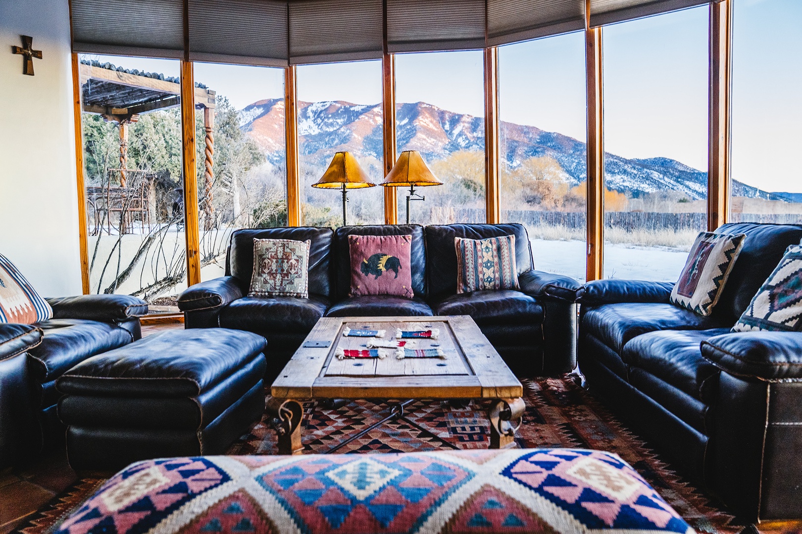Sink into plush leather seating while taking in breathtaking mountain vistas through panoramic windows in this cozy living space.