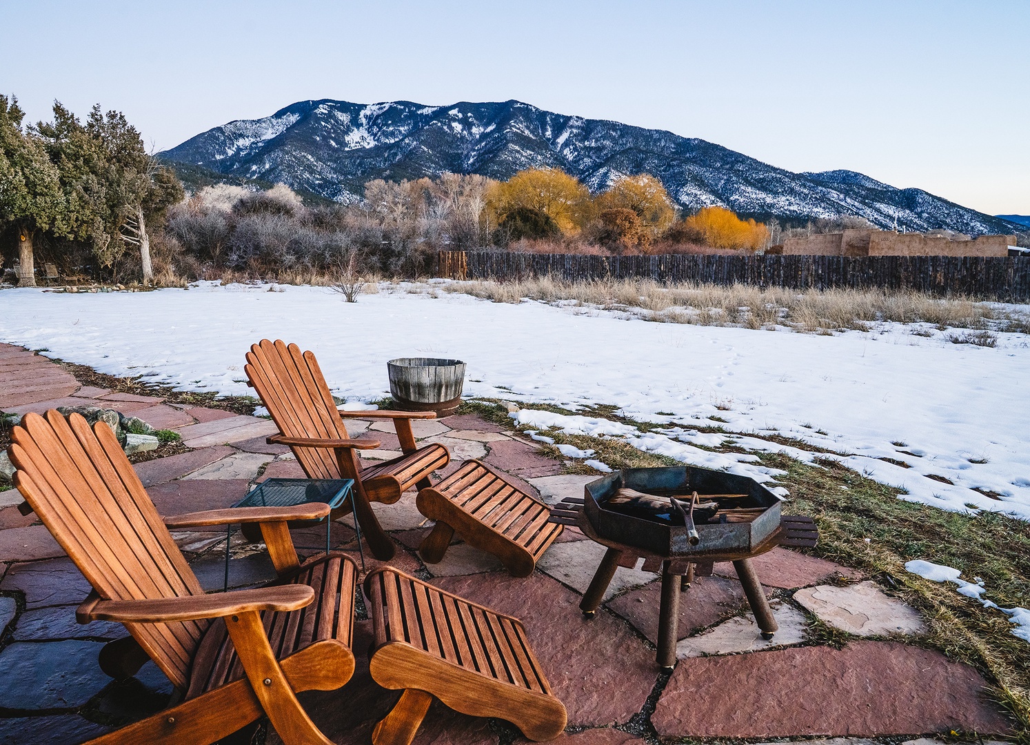 Stunning mountain vista with snow-capped peaks provides dramatic backdrop for this winter retreat property's outdoor seating area.