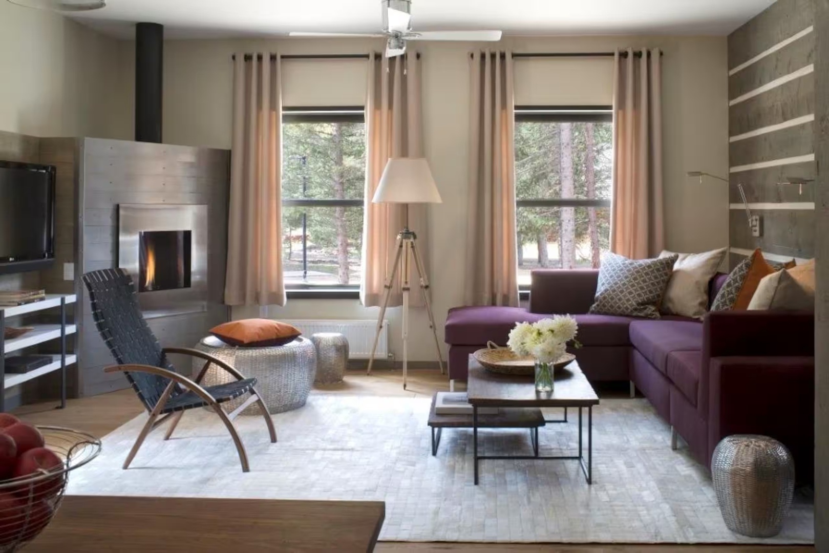 Sink into plush seating by your fireplace while natural light pours through windows framing peaceful forest views—your perfect retreat for cozy mountain evenings.