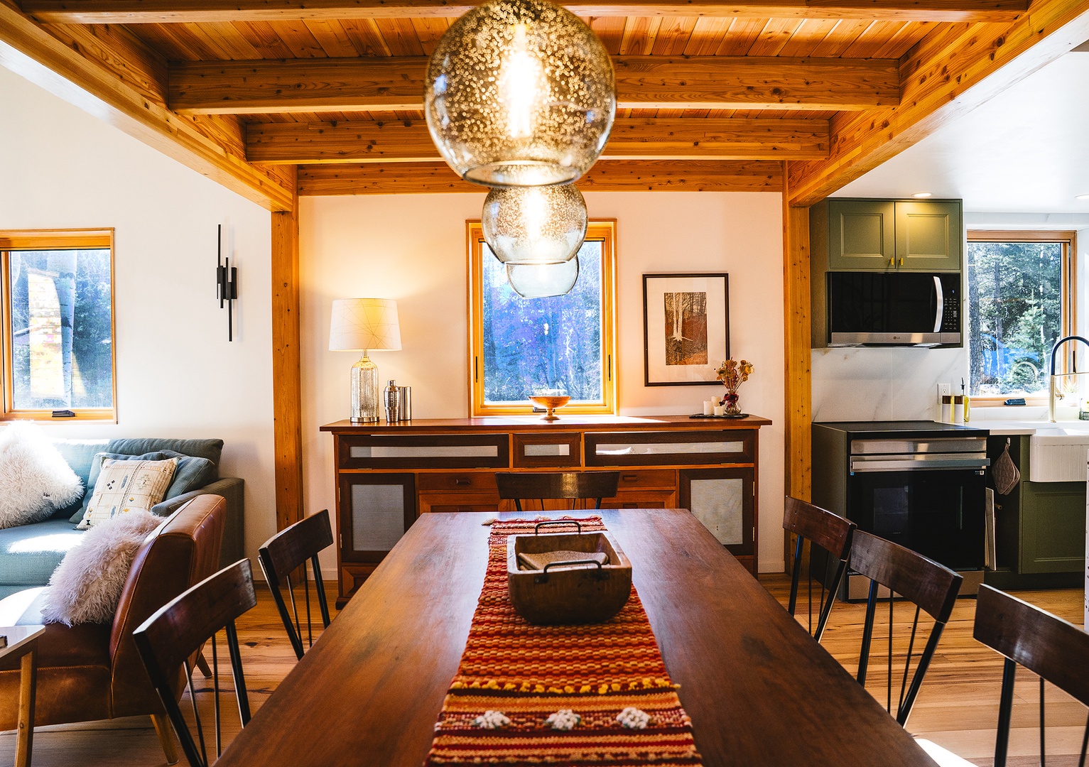 Gather around your stunning dining table beneath warm wood beams and designer lighting for memorable meals together.