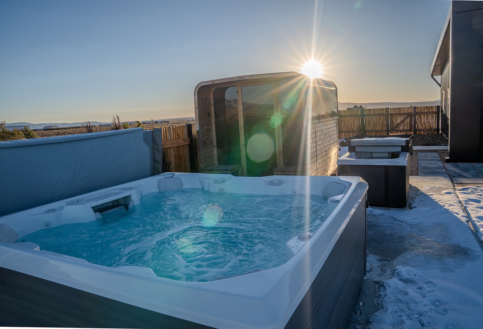Soak in the steaming hot tub while golden sunlight creates a magical winter wonderland around you.
