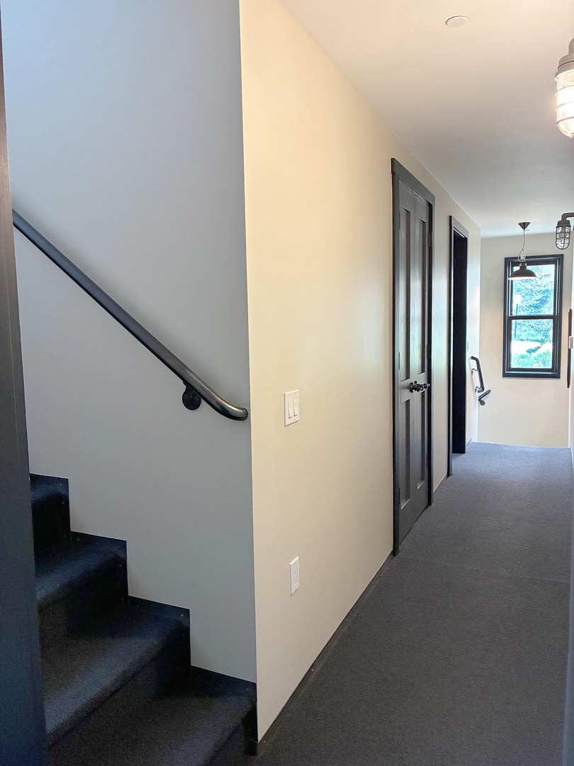 Natural light fills the hallway, creating a bright and welcoming space as you arrive. Clean lines and modern fixtures add to the home's inviting atmosphere.