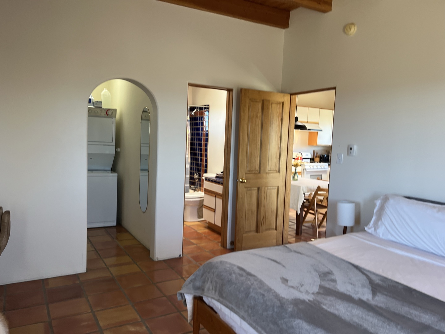 Your spacious bedroom features rustic exposed beams and opens to a charming arched bathroom and bright kitchen—perfect for comfortable extended stays.