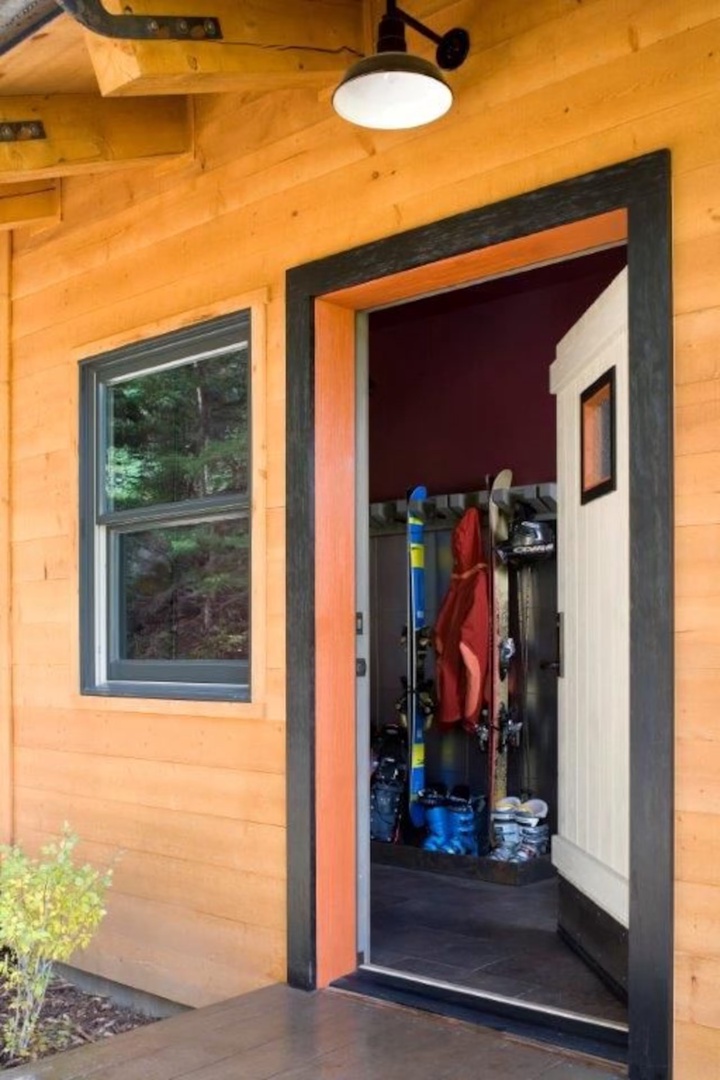 Step inside your cozy mountain retreat, where your gear finds a home just past the welcoming entrance and warm wood surroundings invite you to unwind.