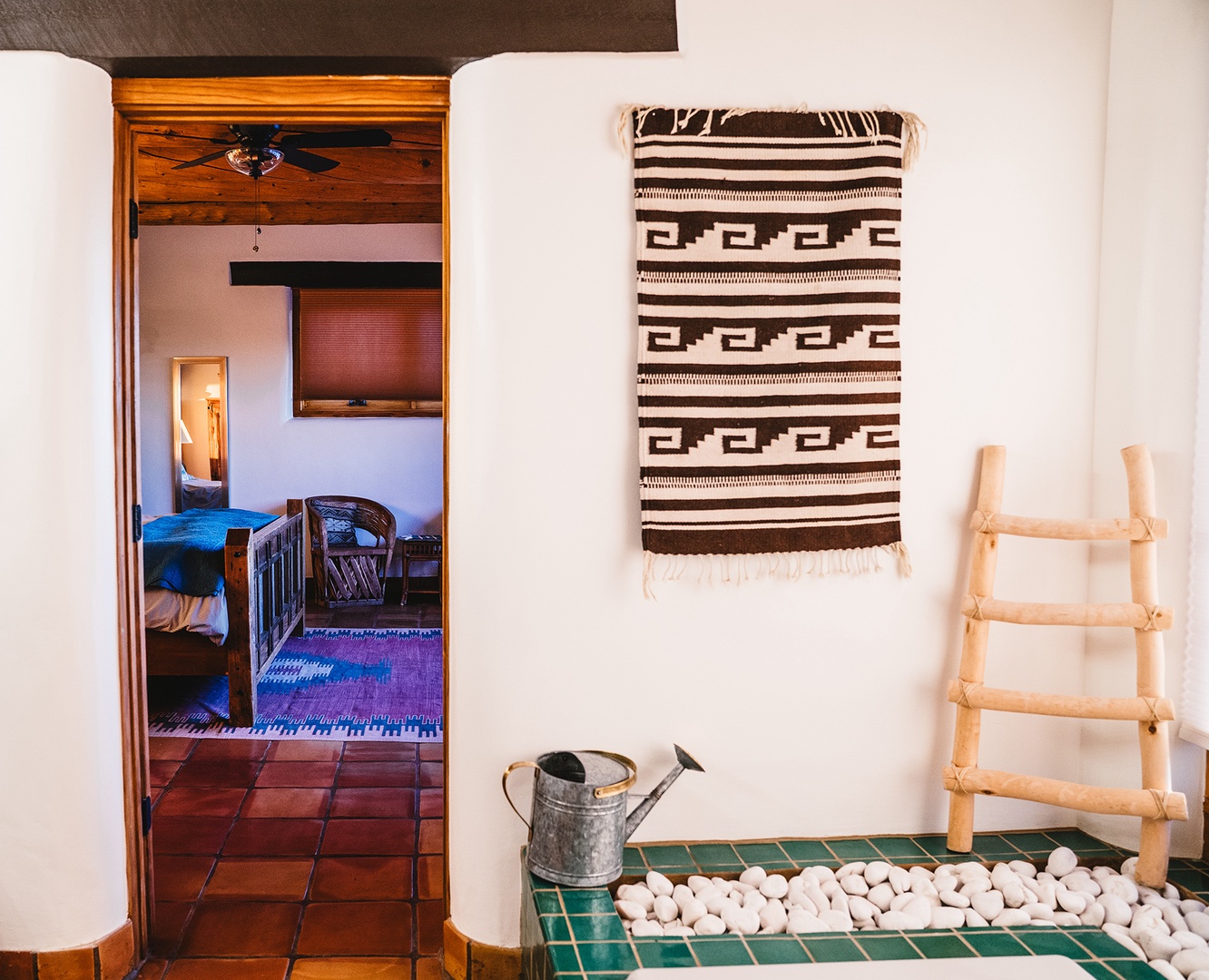 Step into your cozy bedroom through this charming doorway, where rustic tiles and authentic textiles create a warm, inviting sanctuary.