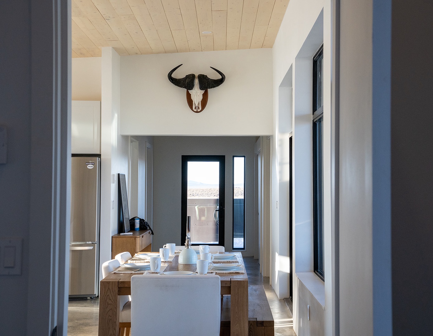 Gather around your rustic dining table beneath striking décor, where morning coffee and evening meals become memorable moments.