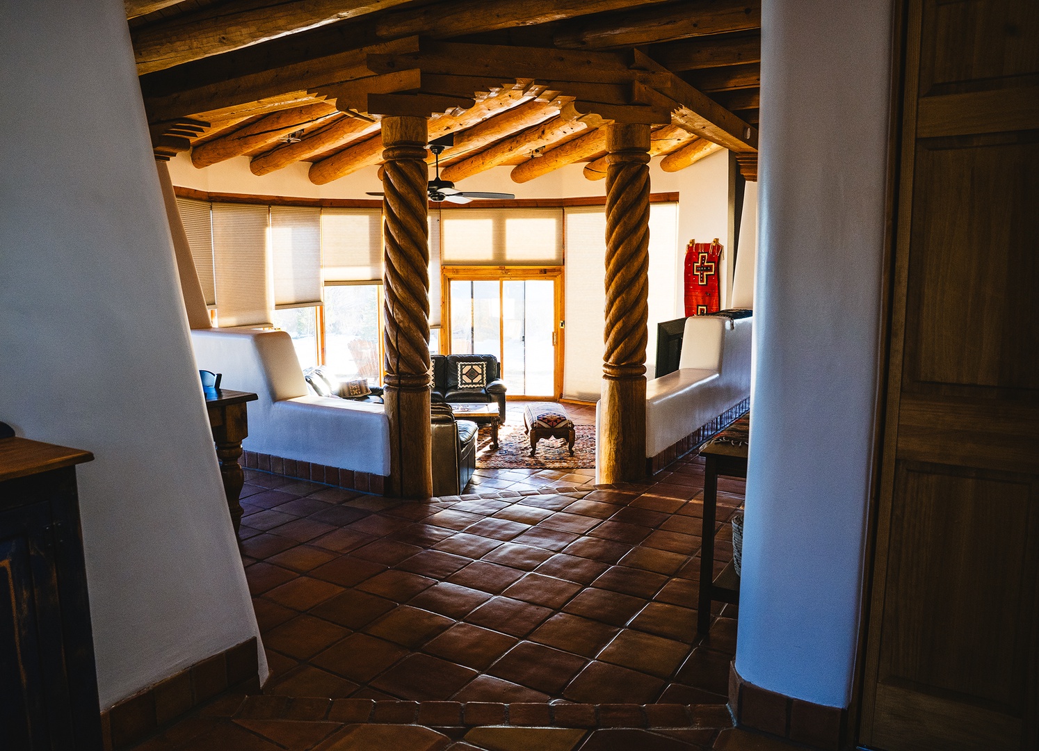 Rustic elegance awaits in your living space, where exposed wooden beams and warm tile floors create the perfect retreat atmosphere.
