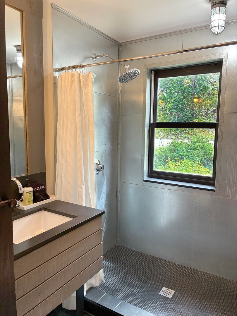 Rinse away the day under a rainfall showerhead with garden views framing your refreshing escape.