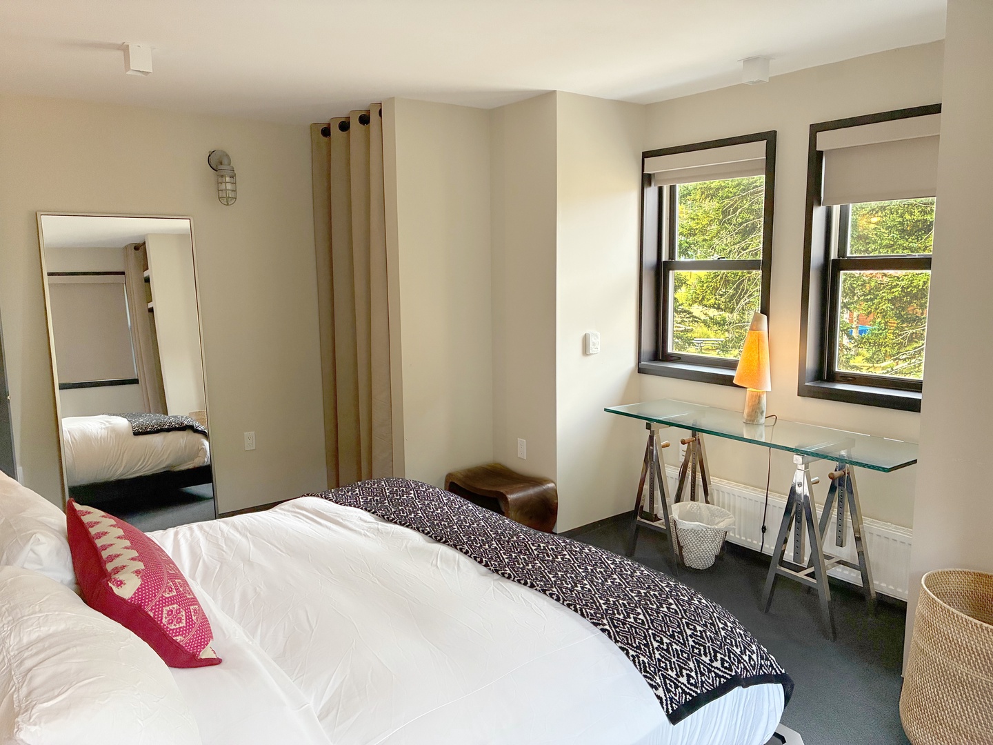 Bright, serene bedroom where you'll wake to leafy views and crisp linens. The stylish glass desk is perfect for planning your next adventure or unwinding with morning coffee.