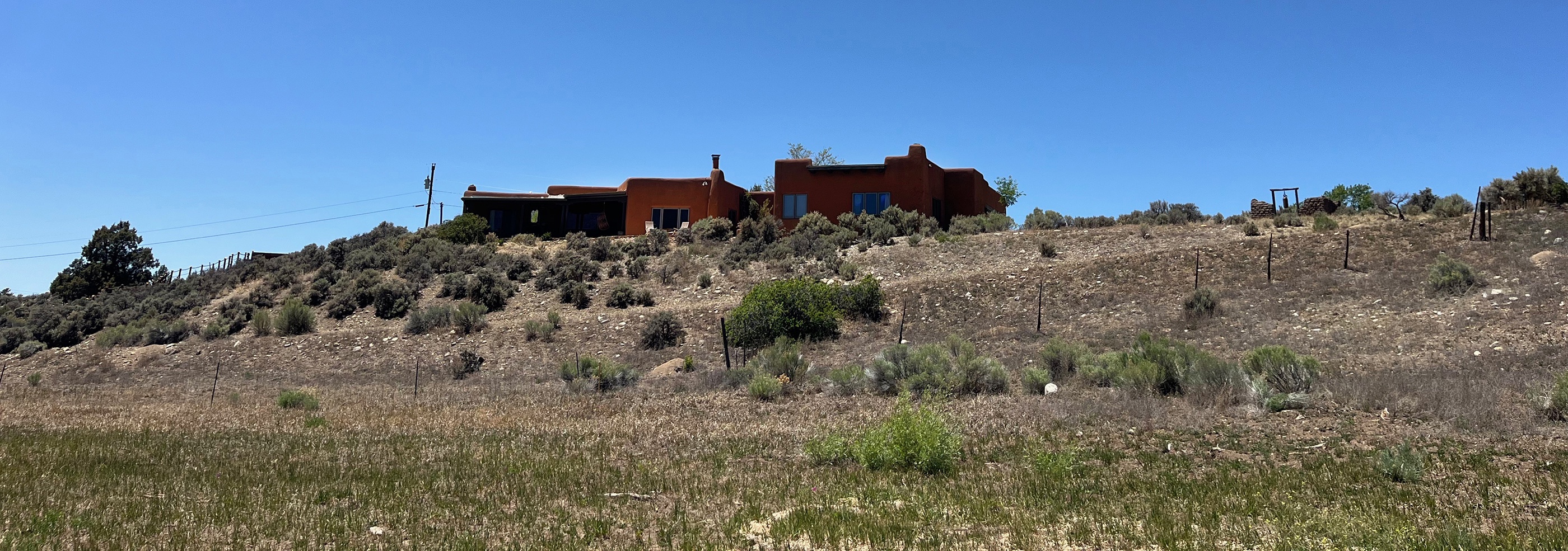 This hillside property sits amid open desert landscape with native vegetation and distant mountain vistas.