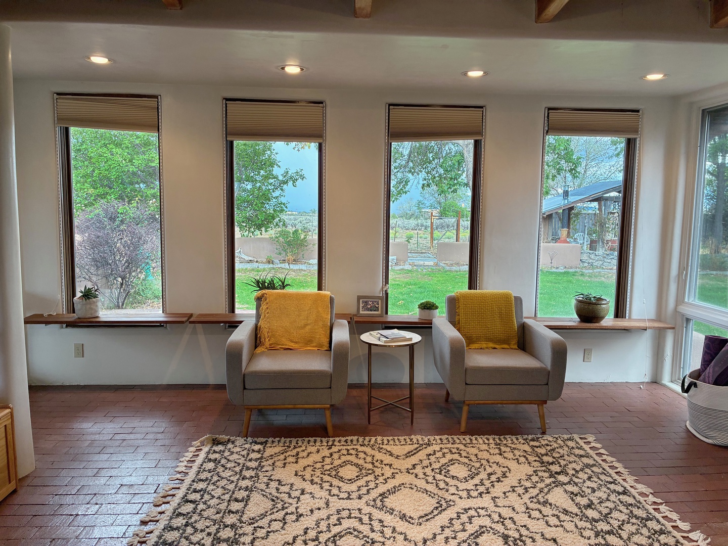 Settle into this peaceful sitting area with mountain views stretching beyond the windows. Warm wood accents and pops of golden yellow create a welcoming retreat where you can relax and take in the natural beauty surrounding you.