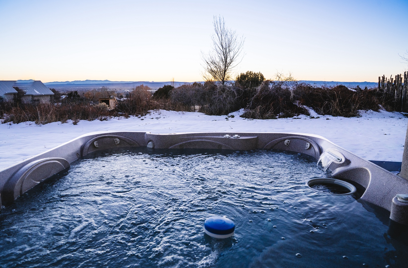 Soak in your private hot tub as winter's beauty surrounds you, with mountain views stretching endlessly beyond the snowy landscape.