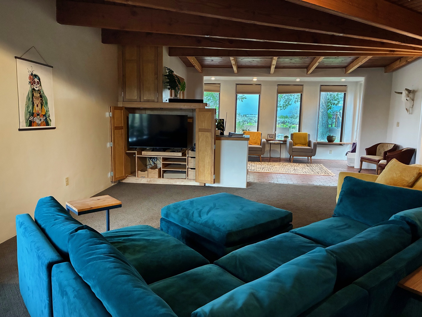 Sink into plush seating and take in stunning natural views through four expansive windows. The warm wood beams overhead and thoughtfully arranged lounge spaces invite you to unwind completely.