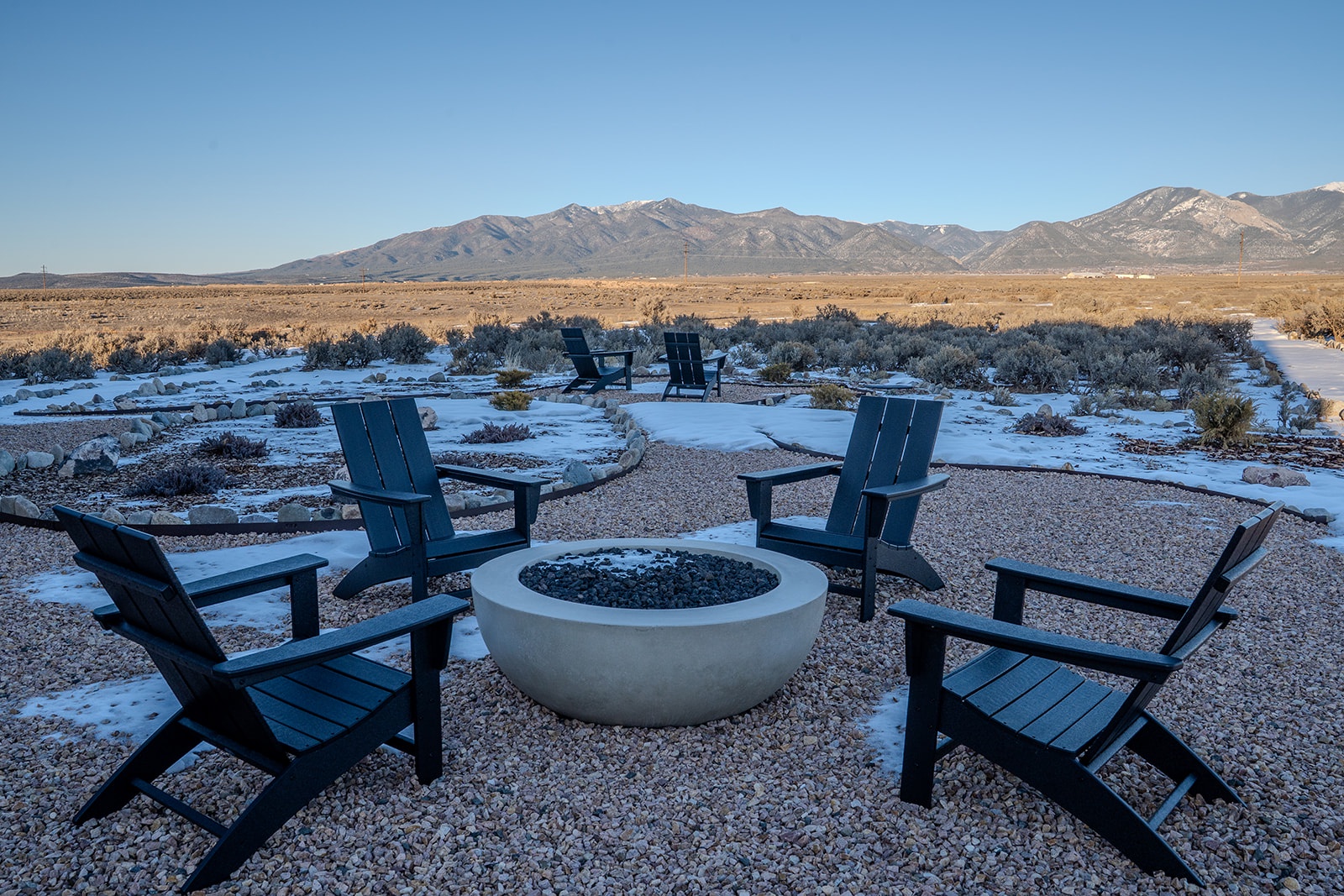 Outdoor fire pit area surrounded by rugged desert landscape and mountain views, perfect for quiet evenings.