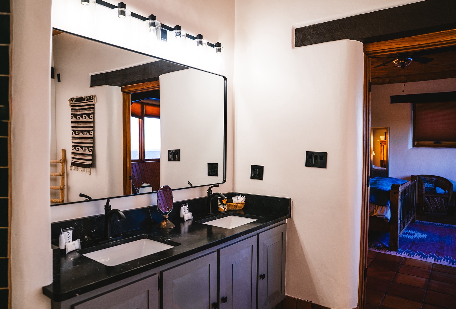 Your spacious vanity features double sinks with elegant black countertops, perfect for getting ready together in this beautifully designed bathroom.