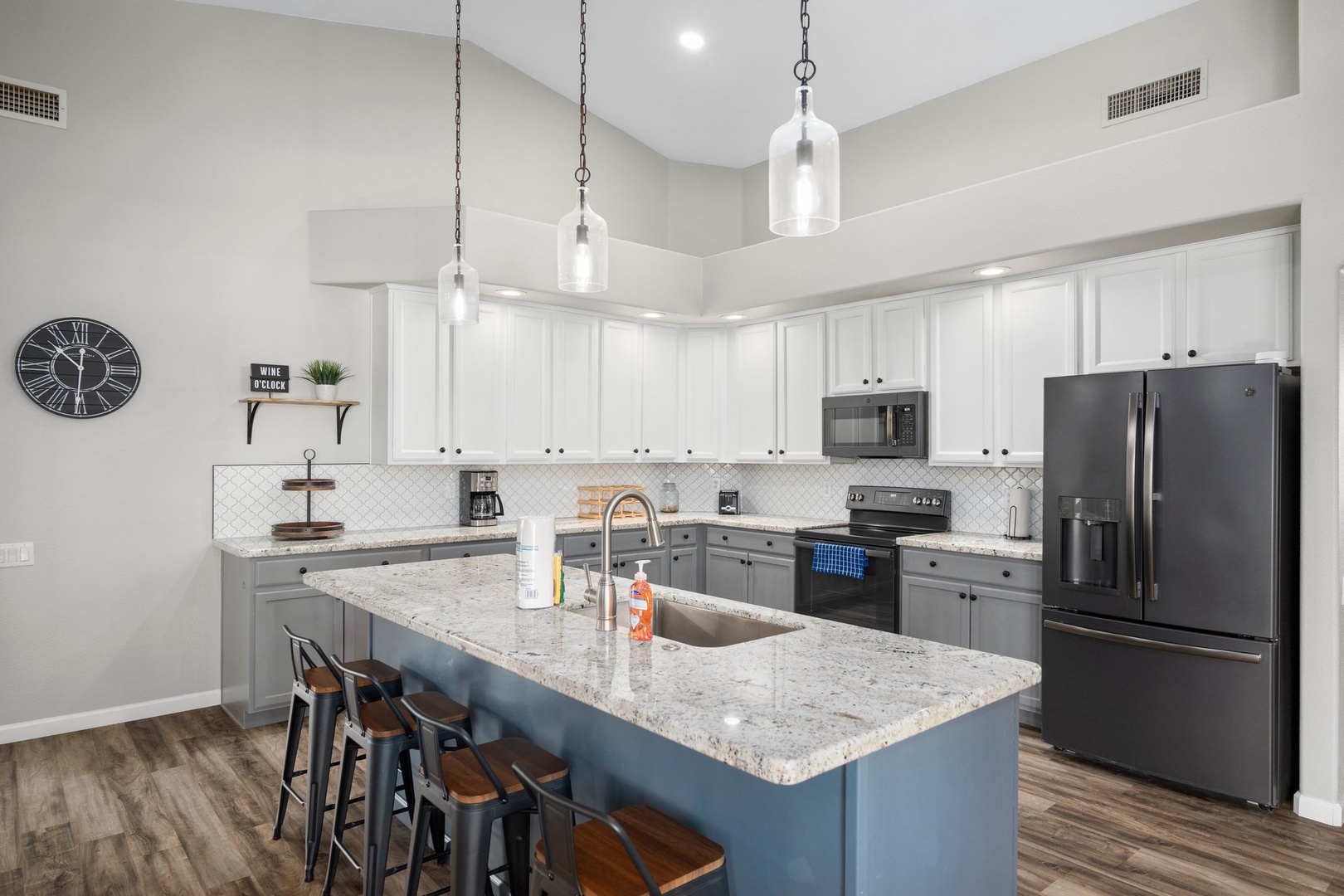 The spacious gourmet kitchen features granite countertops, modern appliances, and a large island with seating—perfect for gathering, cooking, and entertaining during your stay.