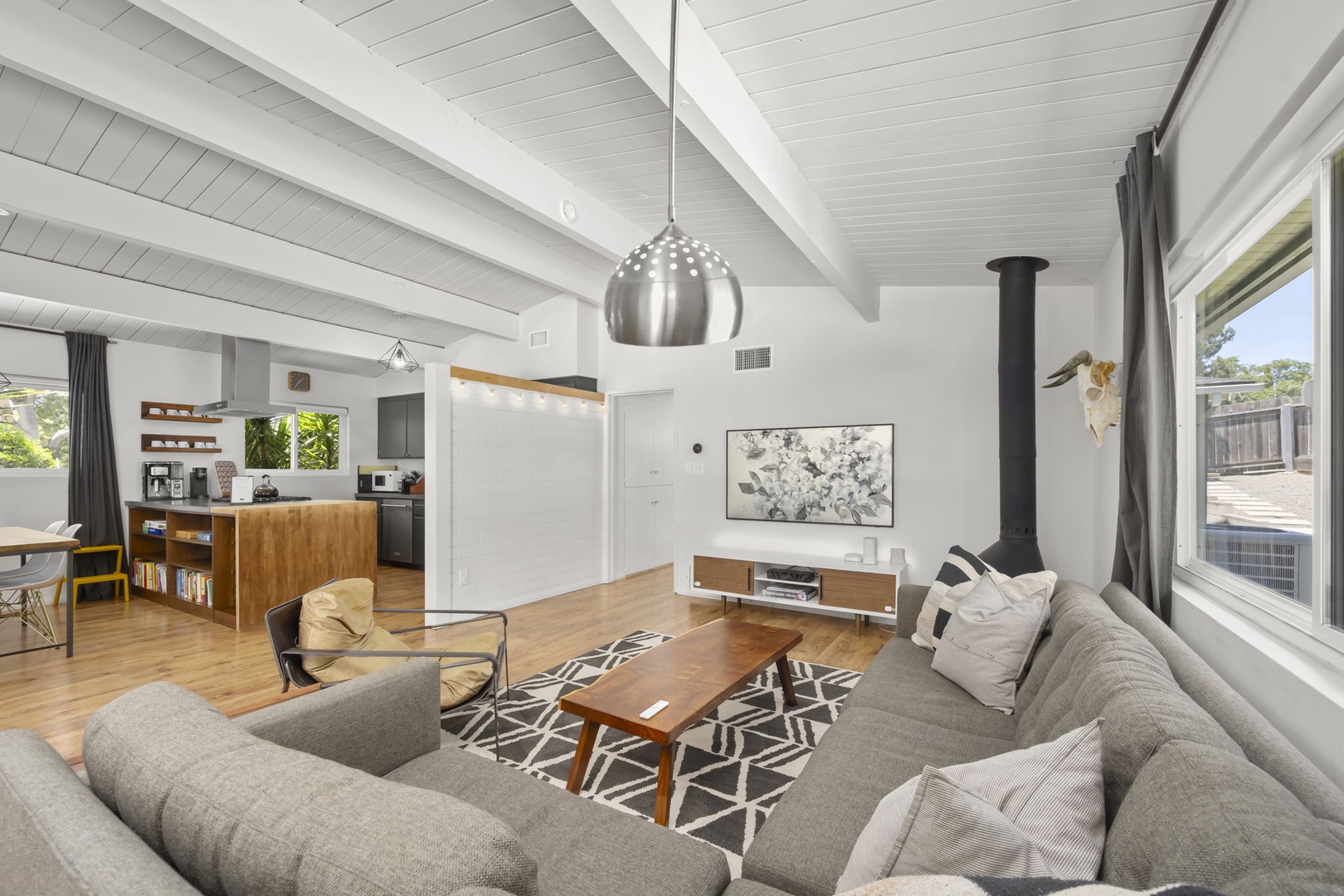 Relax in your spacious open-concept living area with soaring vaulted ceilings, modern furnishings, and warm natural light streaming through large windows—your perfect home away from home awaits.