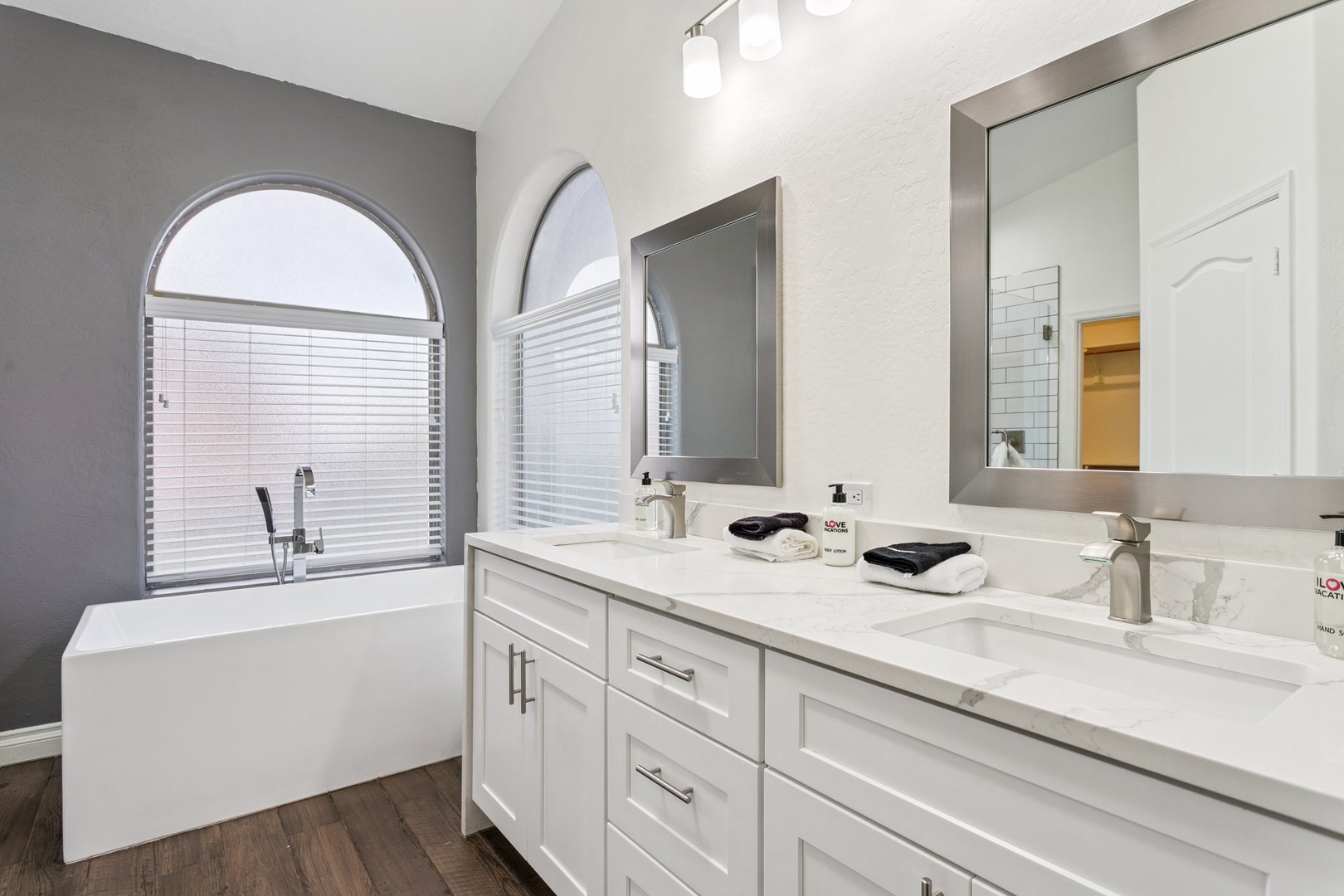 Unwind in your spa-like bathroom with a soaking tub, dual vanities, and elegant arched windows that fill the space with natural light.
