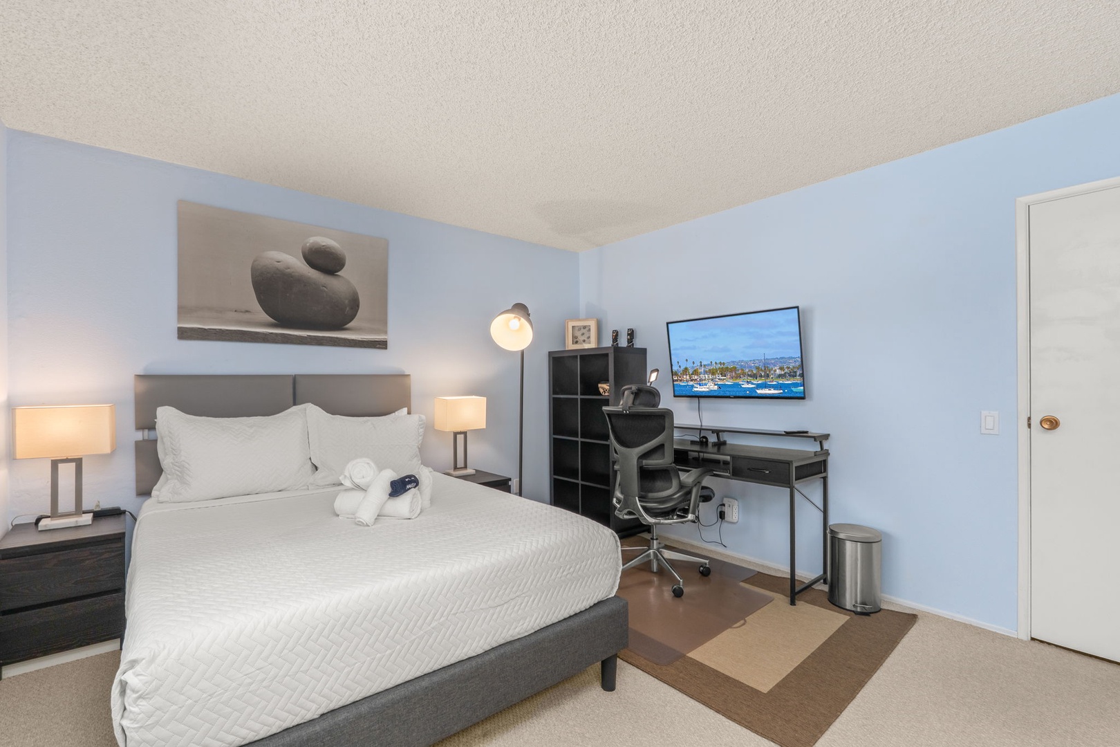 Unwind in your modern bedroom with soft lighting, comfortable bed, and workspace corner for productive mornings.