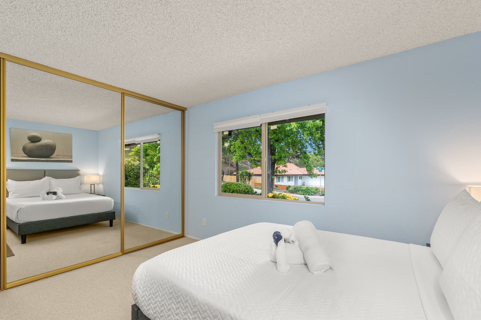 Drift off peacefully in your serene bedroom with soft blue walls, mirrored closets, and lovely garden views from your window.