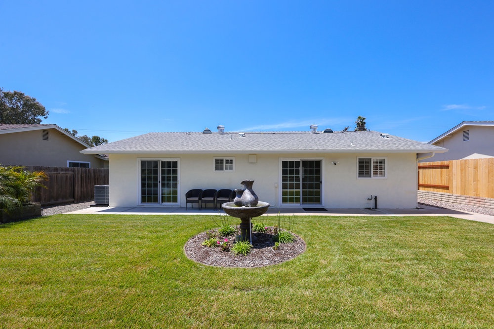 Private fenced backyard with fountain