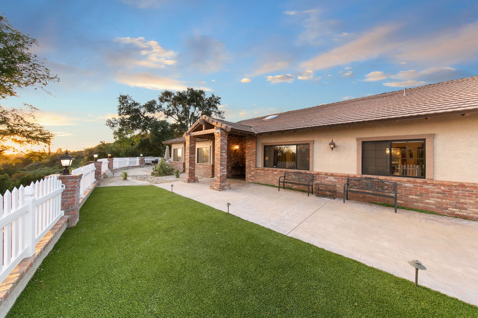Modern single-story home features brick accents and covered entrance. The property sits in a quiet residential setting with manicured landscaping.