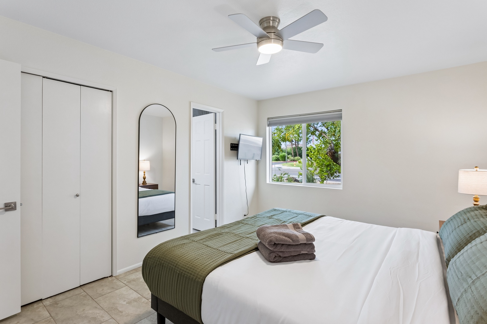 Settle into your bright, serene bedroom where crisp linens and a gentle ceiling fan invite you to unwind after a day of adventure.