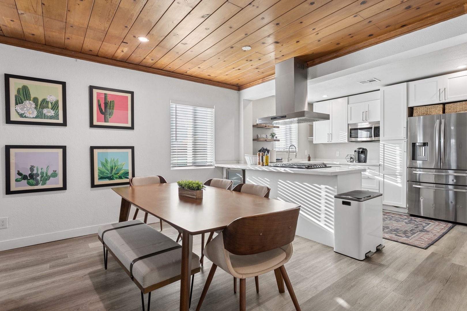 You'll love preparing meals in this modern kitchen with sleek appliances and stylish wood ceiling details creating a warm, inviting atmosphere.