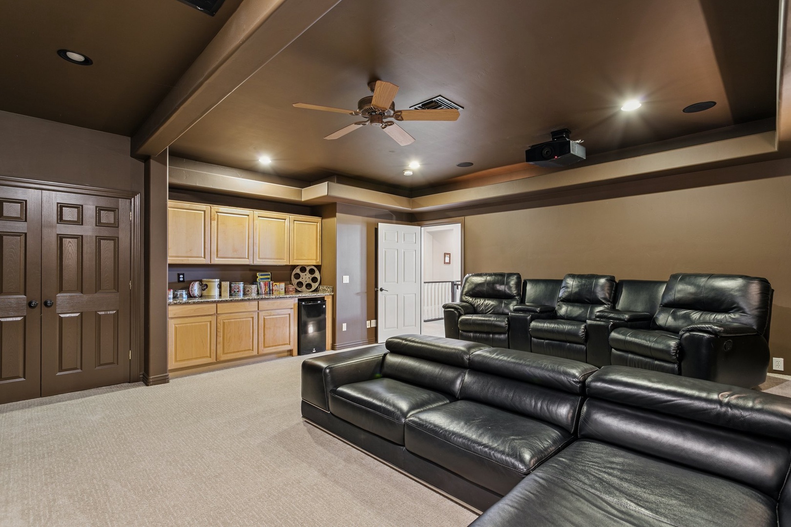 Sink into plush leather recliners in your private home theater, complete with projector and wet bar for movie night magic.