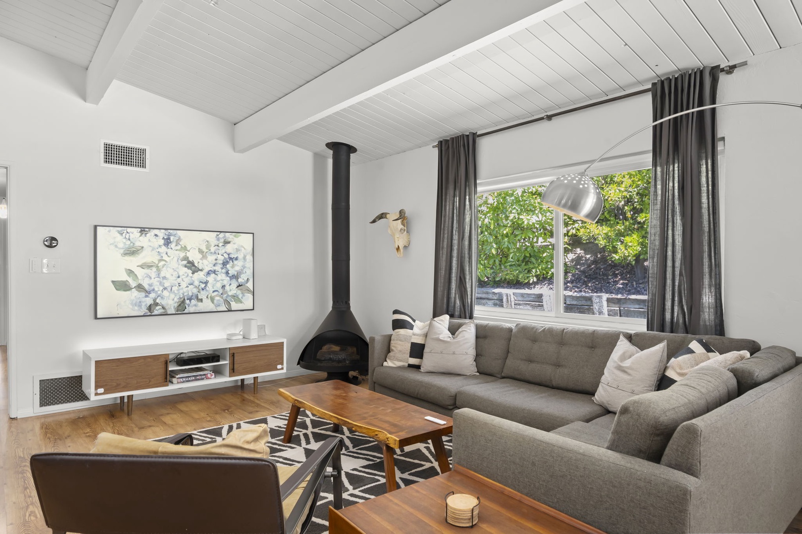 Relax in your spacious open-concept living area with soaring vaulted ceilings, modern furnishings, and warm natural light streaming through large windows—your perfect home away from home awaits.