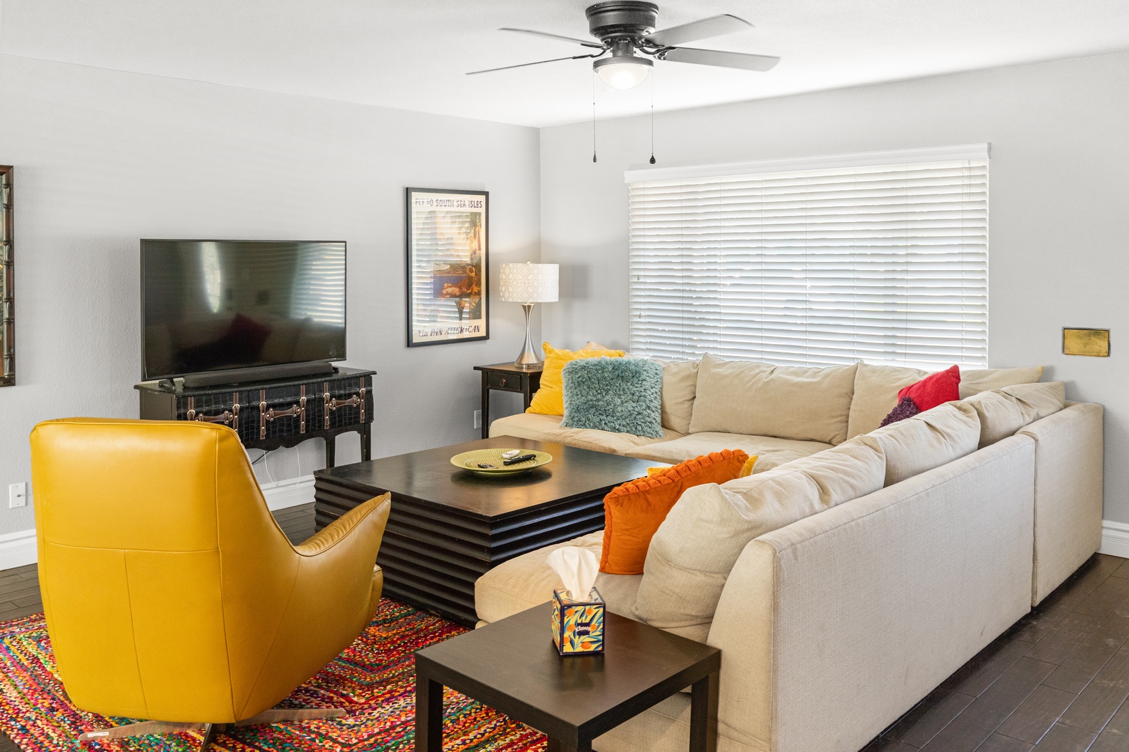 Sink into this plush sectional sofa with colorful cushions while enjoying your favorite shows on the large TV.