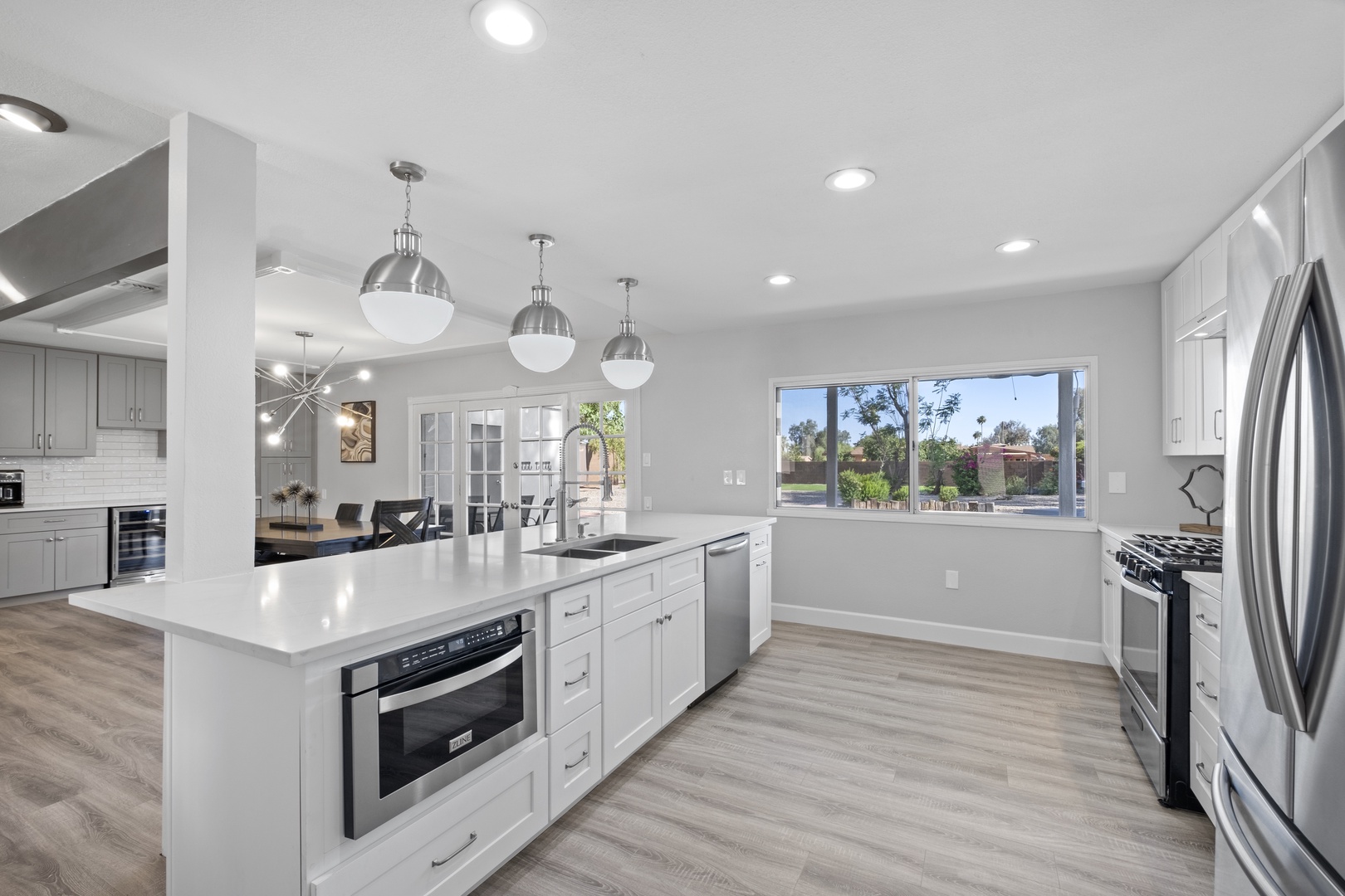 Modern appliances including: dishwasher, fridge, blender, stove top, coffee maker, pots and pans, utensils.