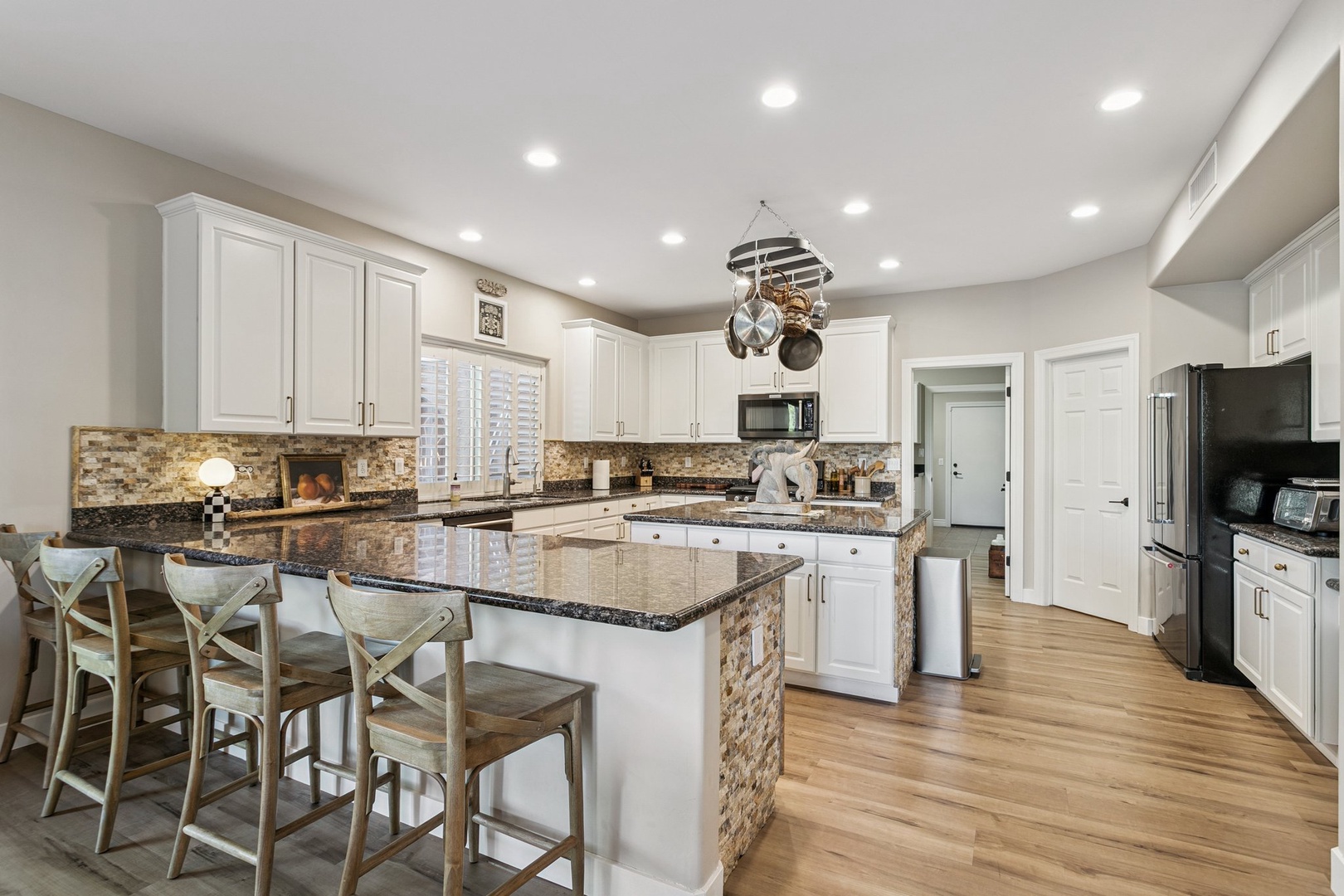Your spacious gourmet kitchen awaits with granite countertops, crisp white cabinetry, and an island perfect for morning coffee or evening conversations.