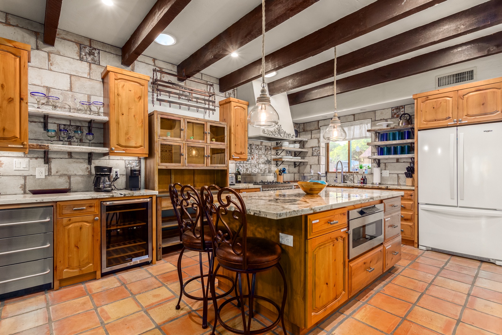 Modern appliances including: dishwasher, fridge, double ovens stove top, drip & Keurig and drip coffee maker, pots and pans, utensils, and a coffee/wine center with built-in wine fridge and additional refrigerated beverage drawers.