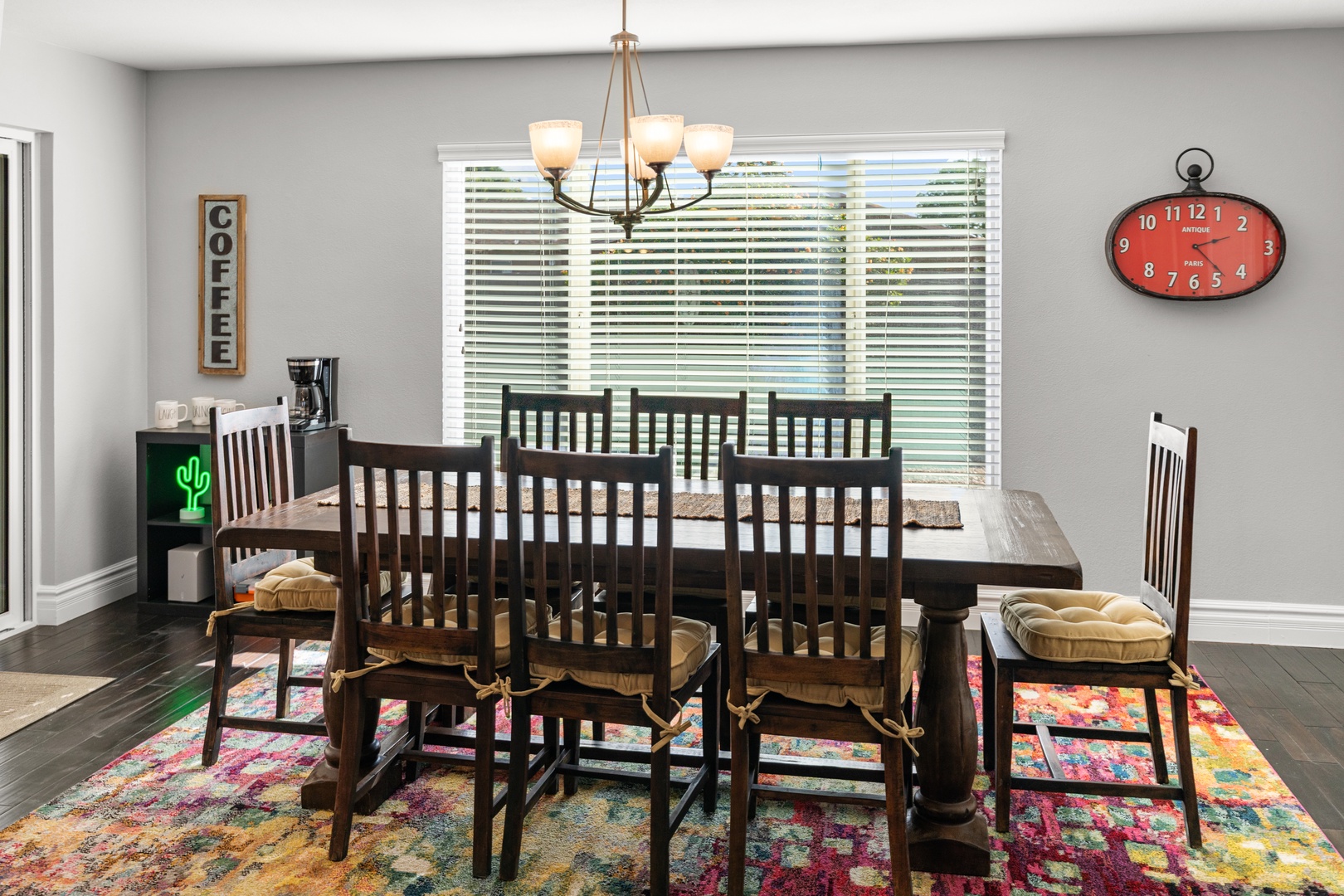 Gather your family around this spacious dining table where warm conversations flow under elegant chandelier light.